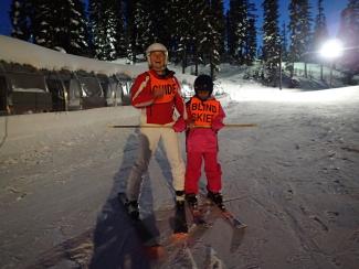 a student on skis with a guide on the slope 