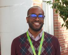 Phillip, smiling and standing outside of the Old Main Building