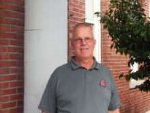 Mark smiling staning outside of the Old main building