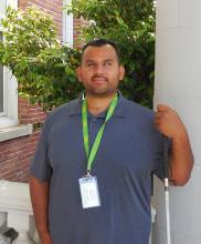 Eli standing outside of the Old Main building smiling