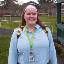 Maegan is standing near the outside track smiling