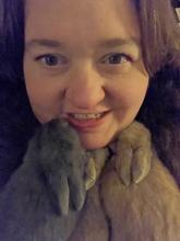 Jennifer smiling with baby bunnies snuggled on her neck
