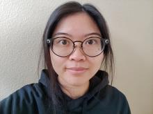 Headshot of Ashley with dark hair and glasses